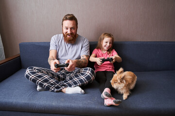 Dad and preschooler daughter sitting on couch