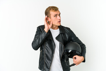Fototapeta premium Young caucasian man holding a motorbike helmet isolated on white background