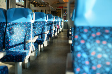 Sun shines on empty seats in train, abstract rail travel concept with shallow depth of field photo...
