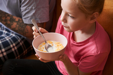 Girl eating corn flakes and watching TV