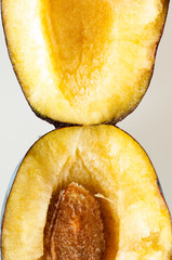 Fresh red plum sliced open to reveal the succulent yellow flesh and pip