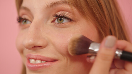 Beauty shot. Young caucasian woman with make up brush near her face. . High quality photo