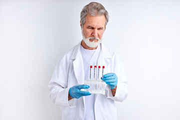 doctor scientist male holds sample tube in hand, examine it. doctor in biohazard protection clothing. covid 19 research laboratory