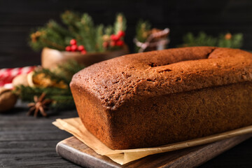 Delicious gingerbread cake on black wooden table, closeup