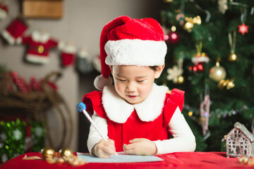 young girl  was writing letter to santa at home