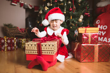 Fototapeta na wymiar young girl sit on floor and open Christmas gift box at home