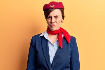 Young beautiful woman wearing stewardess uniform skeptic and nervous, frowning upset because of...