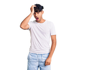 Young hispanic man wearing casual clothes surprised with hand on head for mistake, remember error. forgot, bad memory concept.