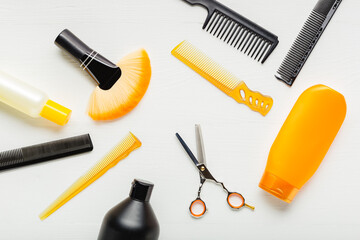 Hairdresser tools, hair salon equipment for professional hairdressing in beauty salon, haircut service. Top view flat lay on white background.Hairbrush, comb, scissors, shampo. Orange black set