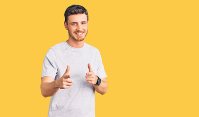 Handsome young man with bear wearing casual tshirt pointing fingers to camera with happy and funny face. good energy and vibes.