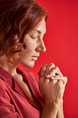 close-up portrait on calm woman praying thinking about something with closed eyes