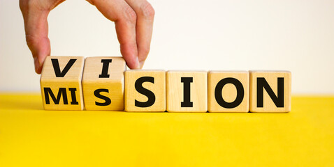 Mission vision symbol. Businessman hand turns wooden cubes and changes the word 'mission' to...