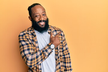 Obraz premium Young african american man wearing casual clothes smiling cheerful pointing with hand and finger up to the side