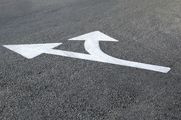 white directional arrows marked on the asphalt