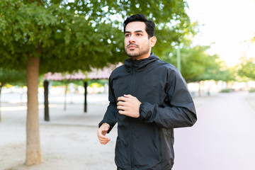 Side view of a fit man running in the park