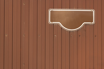 Brown metal fence with an address and number plate. Copy space for the texrt