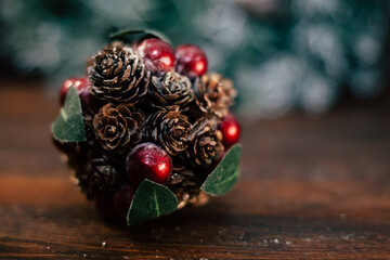 closeup photo of a Christmas decoration feturing gold-dusted cones and red berries - 397916690