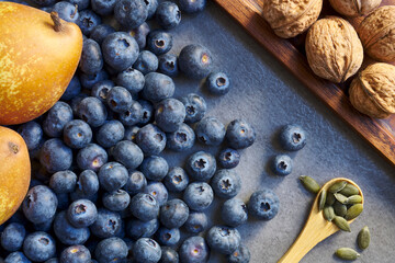 Freshly picked organic blueberries, pears, pumpkin seeds and walnuts. Winter harvest. Top view shot.