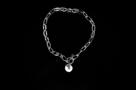 Silver jewelry chain with medallion isolated on black background