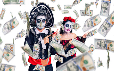 Young couple wearing mexican day of the dead costume over background pointing aside worried and nervous with both hands, concerned and surprised expression
