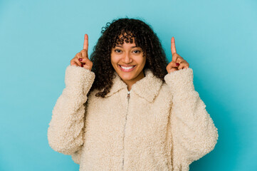 Young african american afro woman isolated indicates with both fore fingers up showing a blank...