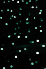 Faded green lights blurred background. Laser dots on black backdrop for celebrating events and greeting cards