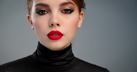 Beautiful woman with bright professional makeup. Closeup cinematic footage of an sexy girl with a red lipstick on lips. Model with a fashion brown eye make-up. SLOW MOTION. BMPCC4K. 12 bit ProRes.