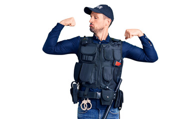 Young handsome man wearing police uniform showing arms muscles smiling proud. fitness concept.