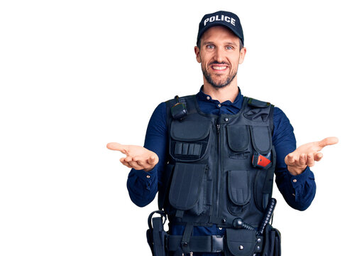 Young handsome man wearing police uniform smiling cheerful offering hands giving assistance and acceptance.