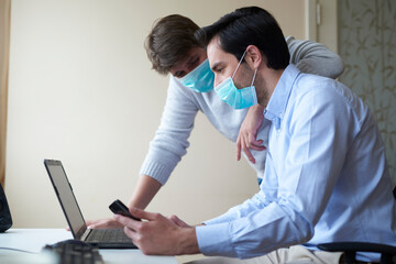 Two young handsome businessman looking at their laptop