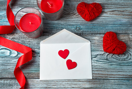 Two red hearts on a white envelope on a romantic background. Top view, with space to copy. Concept February 14.