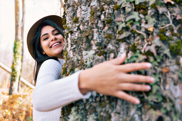 smiling woman hugging a tree