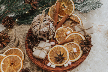 Still life details in home interior. Cozy winter concept with cinnamon, pine cones, cookies, marshmallows, garland and gifts