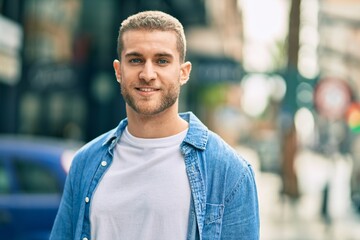 Young caucasian man smiling happy standing at the city.