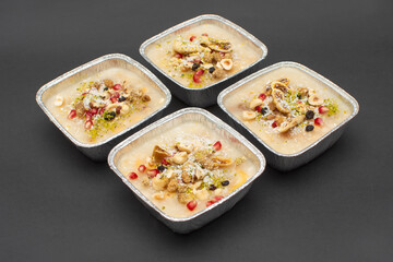 Closeup of traditional Turkish Dessert Asure or Ashura (aka Noah Pudding) in disposable aluminum...