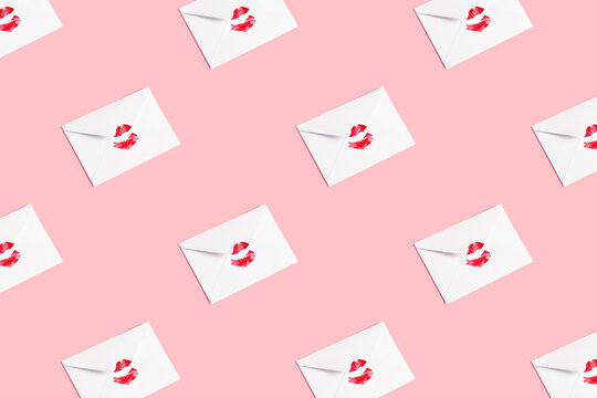Red lipstick kiss on white envelope on pink pastel background. Minimal correspondence concept. Love letter.