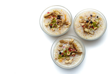 Closeup of traditional Turkish Dessert Asure or Ashura (aka Noah Pudding) in glass bowls isolated on white background. with copy space for text. 