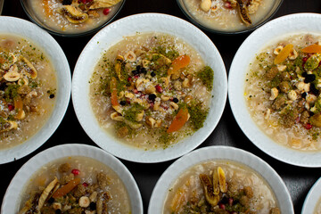 Closeup of traditional Turkish Dessert Asure or Ashura (aka Noah Pudding) in white bowls isolated on black backgroun