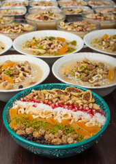 Closeup of traditional Turkish Dessert Asure or Ashura (aka Noah Pudding) in white bowls isolated on black backgroun