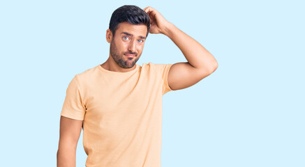 Young hispanic man wearing casual clothes confuse and wonder about question. uncertain with doubt,...