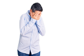 Young woman with short hair wearing business clothes with sad expression covering face with hands while crying. depression concept.