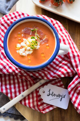 Closeup view of a bowl of salmorejo, a spanish cold delicious tomato soup tagged using lettering...