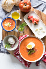 Closeup view of a cold spanish tomato soup ingredients on a wooden cutting board.