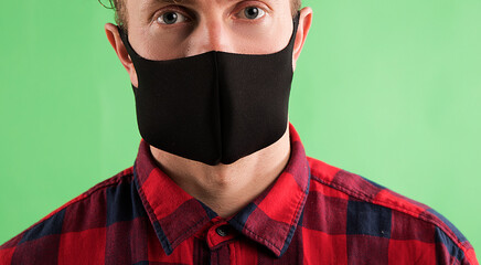 health, quarantine and pandemic concept - young man wearing protective medical mask for protection...