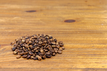 Pile of roasted artesanal gourmet coffee beans pattern on a wood table