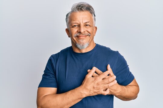 Middle age grey-haired man wearing casual clothes smiling with hands on chest, eyes closed with grateful gesture on face. health concept.