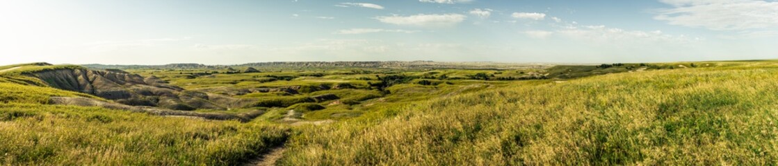 Fototapeta premium Panorama shot of wrinkled landscape in Badlands national park after sunrise in america