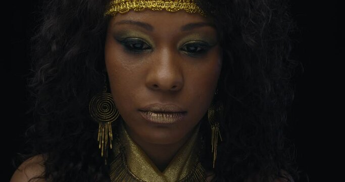 Portrait of a young beautiful african woman wearing jewelry and golden clothes