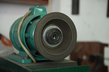 Fototapeta premium Green electric motor with round rotating pulley in the production room