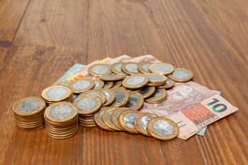 Lot of brazilian coins and bank notes on a wood table